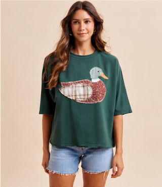 Woman wearing green Mallard Duck Patchwork Knit Top with plaid and floral duck appliqué.
