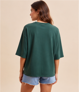 Woman wearing green Mallard Duck Patchwork Knit Top with plaid and floral duck appliqué.