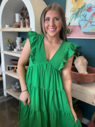 woman wearing emerald green ruffle sleeve tiered boutique dress
