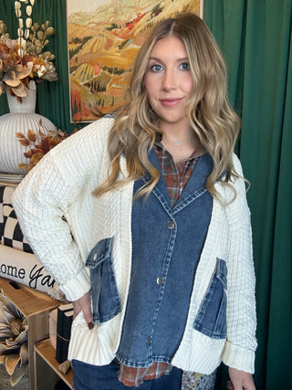 Woman wearing a cream open-knit twofer sweater with a washed-denim button front, flap pockets, and plaid collar accent.