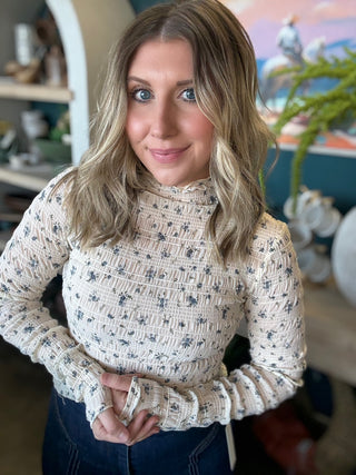 woman wearing floral smocked mock neck boutique top with long sleeves