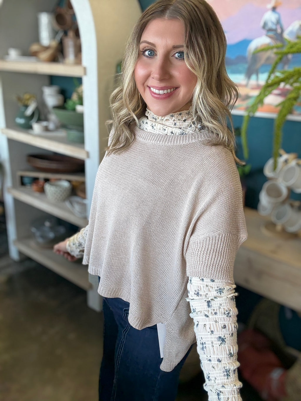 woman wearing oatmeal knit sweater layered over floral textured long sleeve top