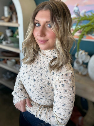 woman wearing floral smocked mock neck boutique top with long sleeves