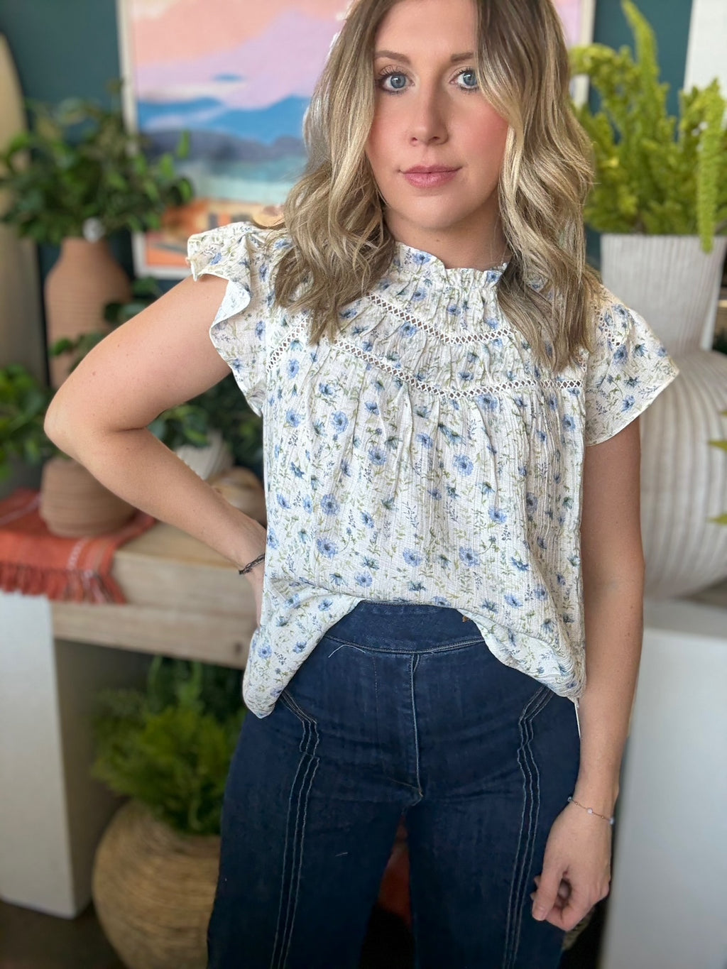 woman wearing cream and blue floral boutique blouse with ruffle neckline