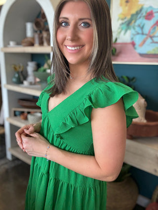 woman wearing emerald green ruffle sleeve tiered boutique dress