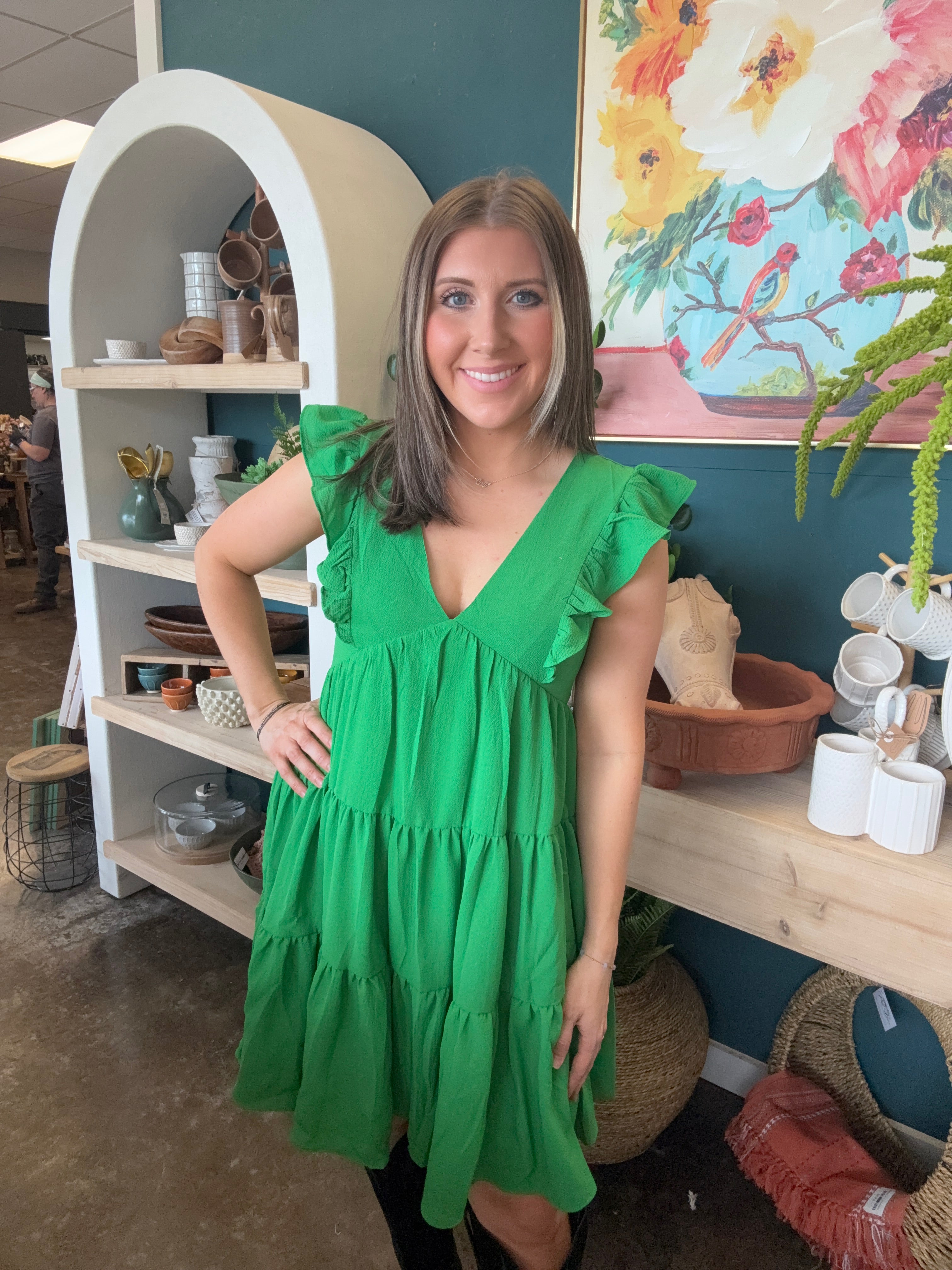 woman wearing emerald green ruffle sleeve tiered boutique dress