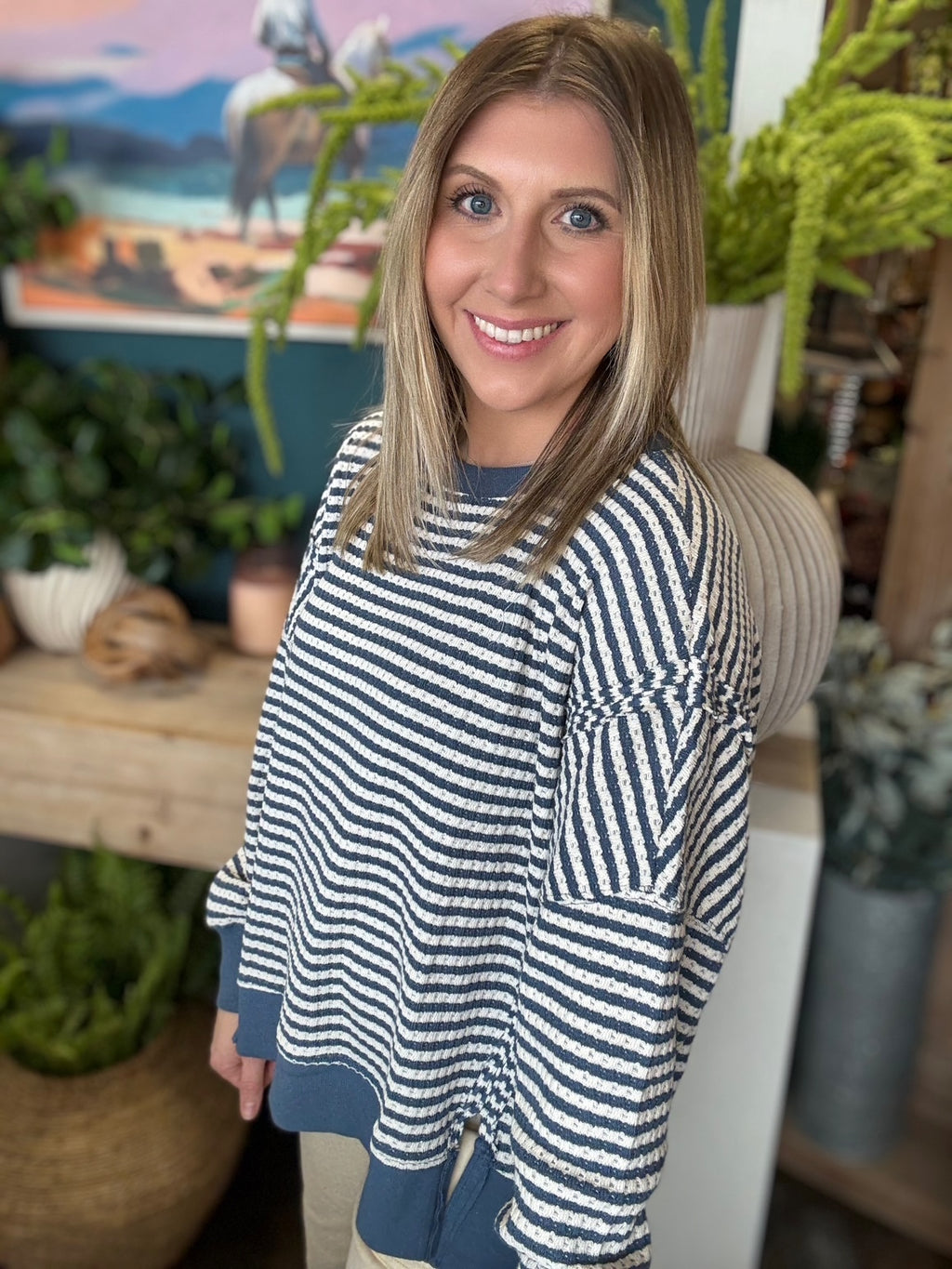 Navy and cream striped relaxed fit boutique top styled with neutral pants at Pill Box Boutique