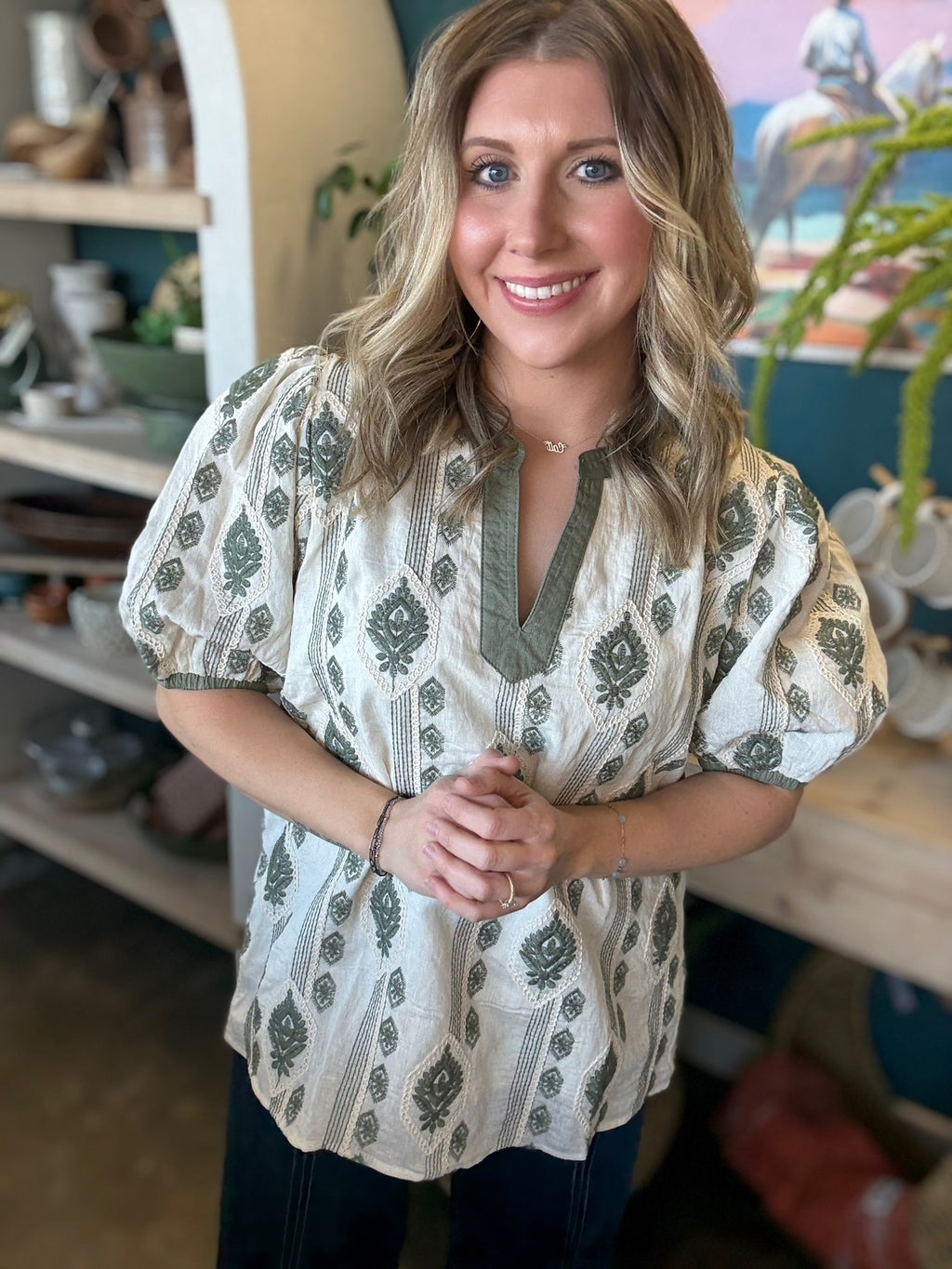woman wearing ivory and olive printed puff sleeve boutique top with split neckline