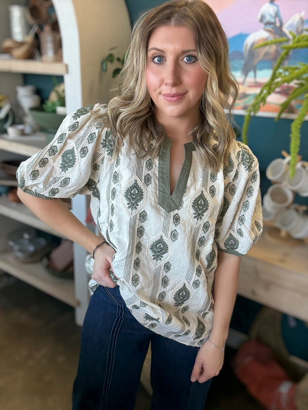 woman wearing ivory and olive printed puff sleeve boutique top with split neckline