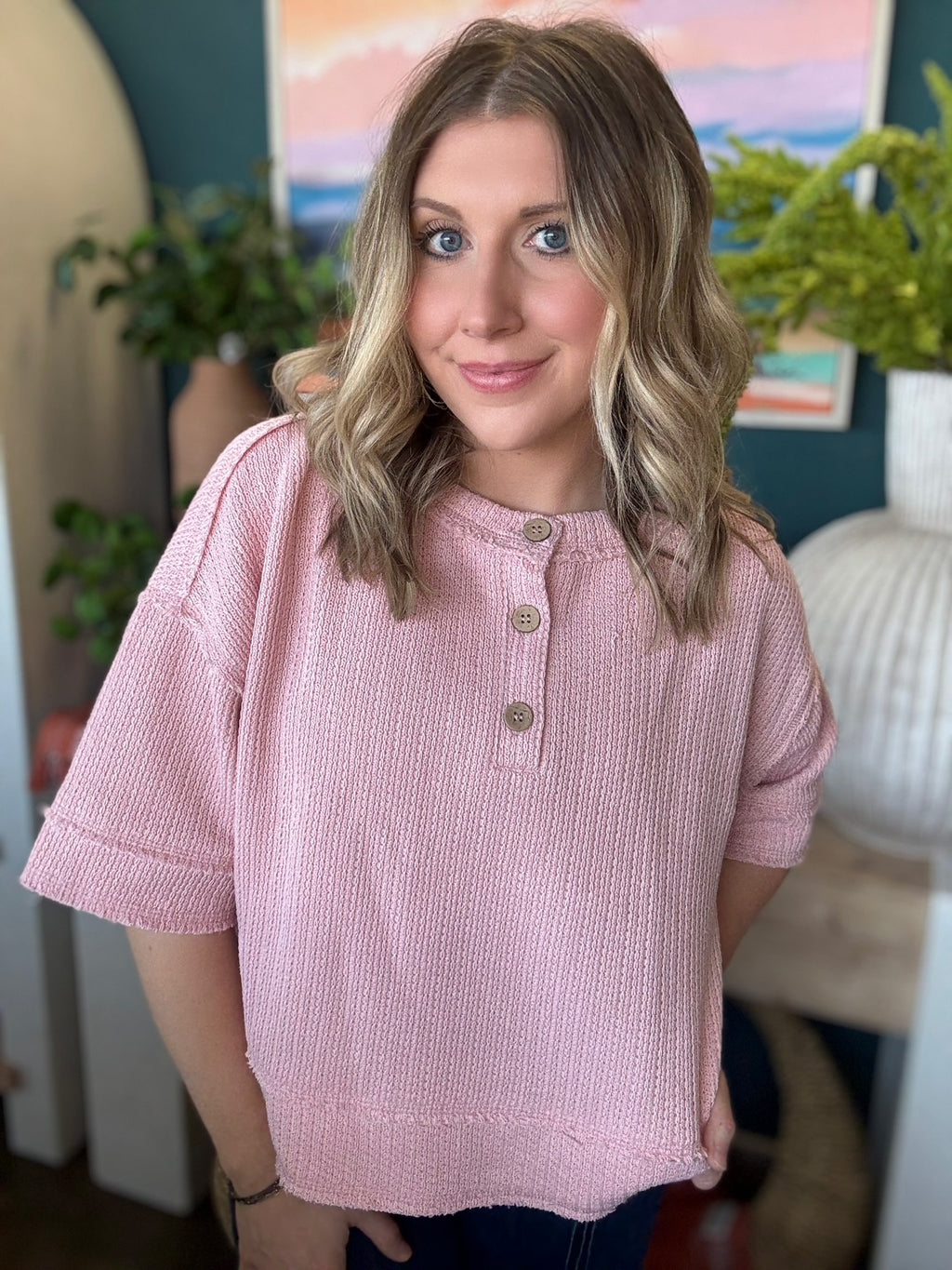 woman wearing blush pink waffle knit boutique top with button neckline