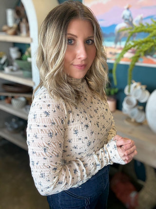 woman wearing floral smocked mock neck boutique top with long sleeves