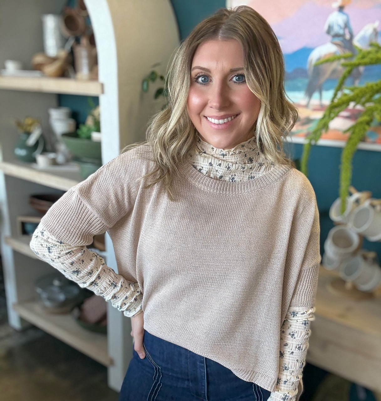 woman wearing oatmeal knit sweater layered over floral textured long sleeve top