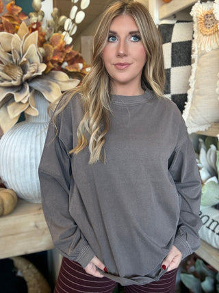 Woman wearing an oversized mocha mineral-wash long-sleeve tee with a crew neckline and gathered cuffs