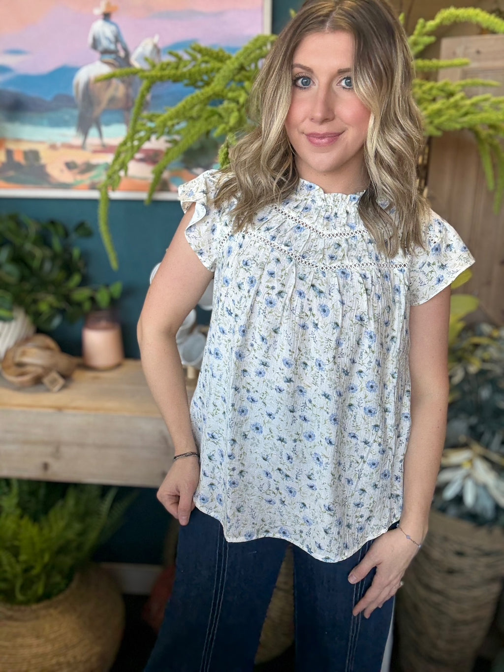 woman wearing cream and blue floral boutique blouse with ruffle neckline