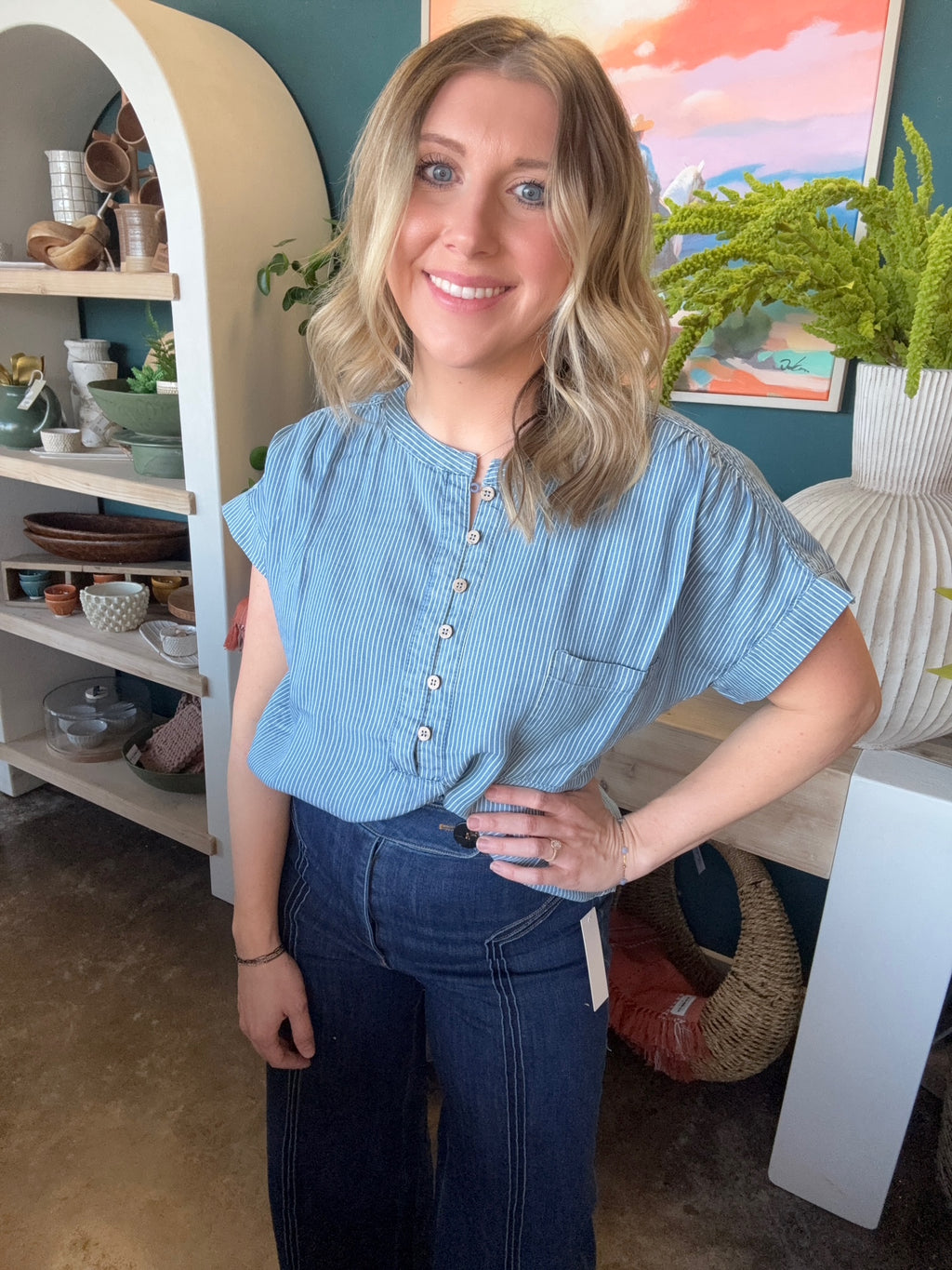 woman wearing blue and white pinstripe boutique blouse with button front