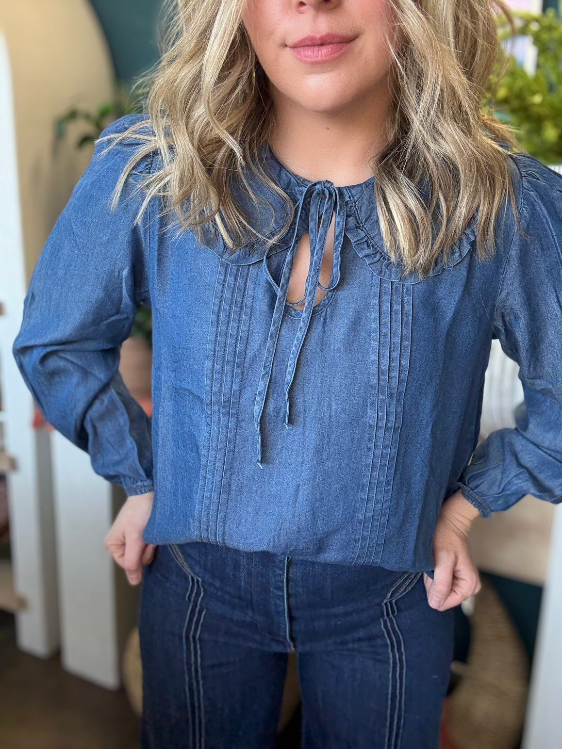 woman wearing chambray boutique blouse with tie neckline and pintuck detailing