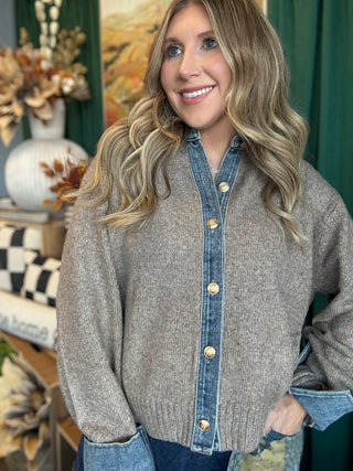 Woman wearing a latte knit sweater with a washed-denim collar, button placket, statement cuffs, and gold-tone buttons.