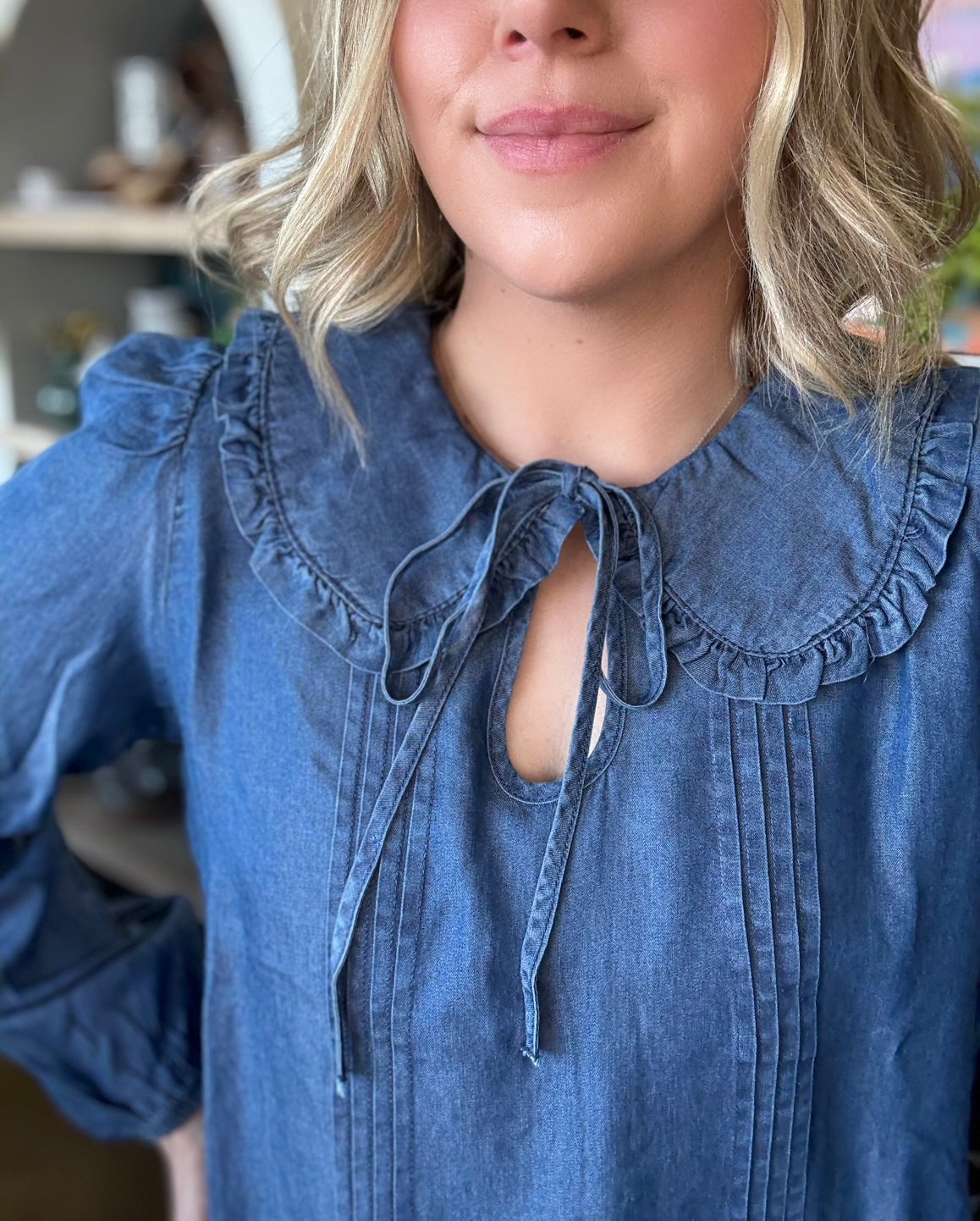 woman wearing chambray boutique blouse with tie neckline and pintuck detailing