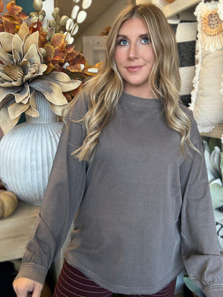 Woman wearing an oversized mocha mineral-wash long-sleeve tee with a crew neckline and gathered cuffs