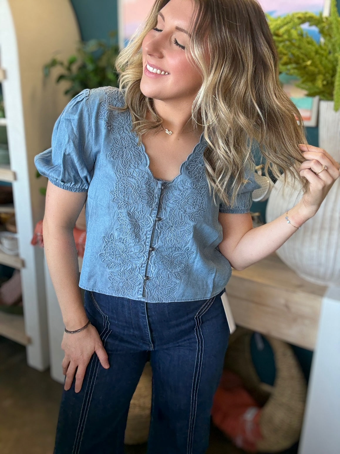 woman wearing embroidered chambray boutique top with puff sleeves and button front