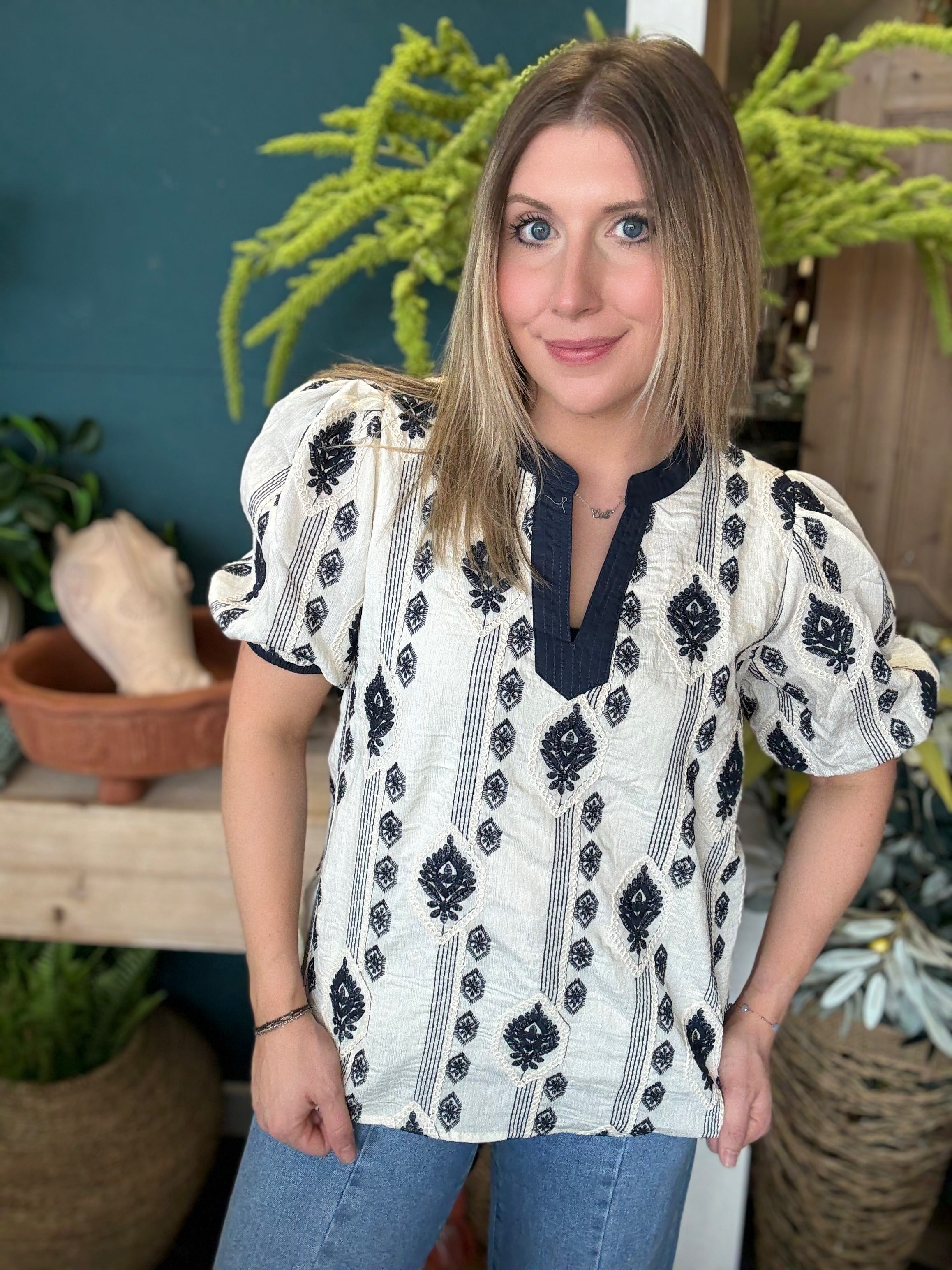woman wearing boho embroidered split neck boutique blouse with black pattern