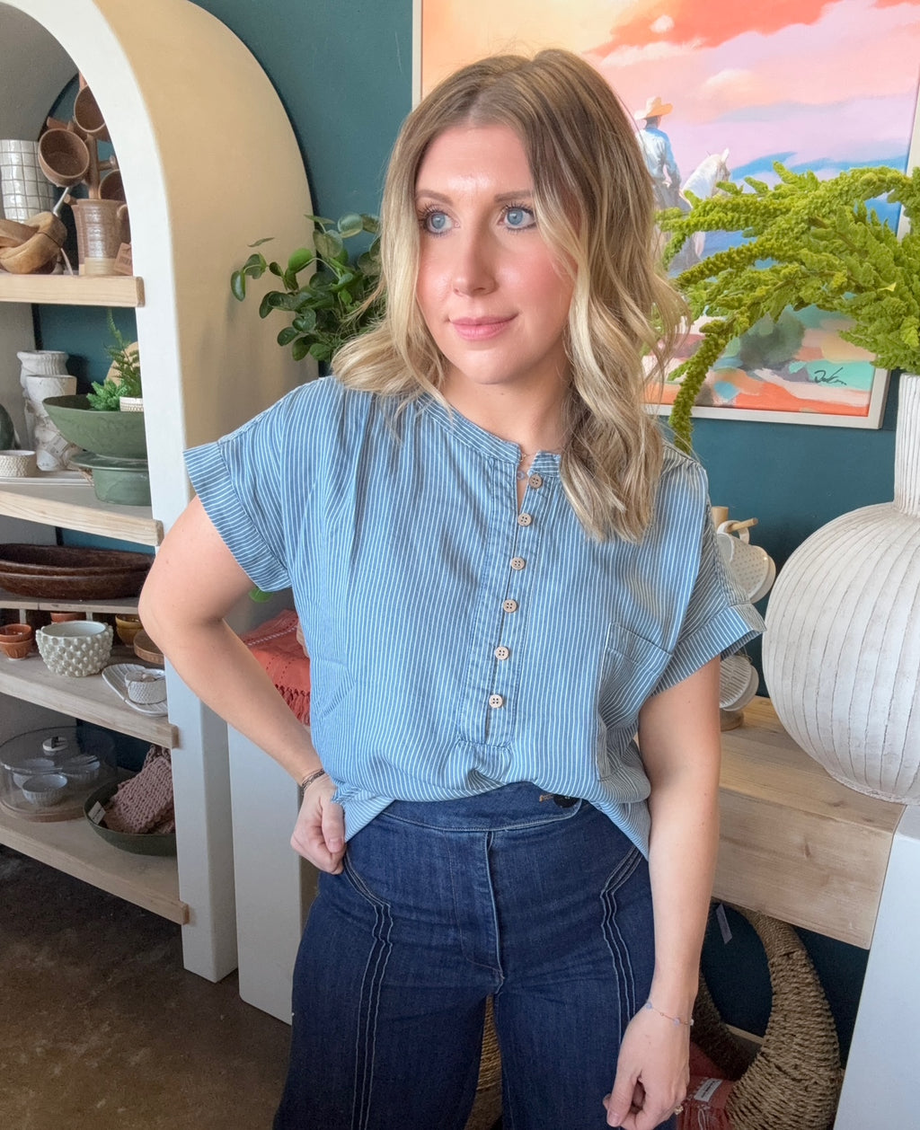 woman wearing blue and white pinstripe boutique blouse with button front