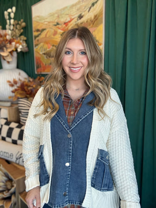 Woman wearing a cream open-knit twofer sweater with a washed-denim button front, flap pockets, and plaid collar accent.