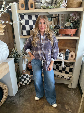 Woman wearing an oversized charcoal, taupe, cream, and brown plaid button-down shirt