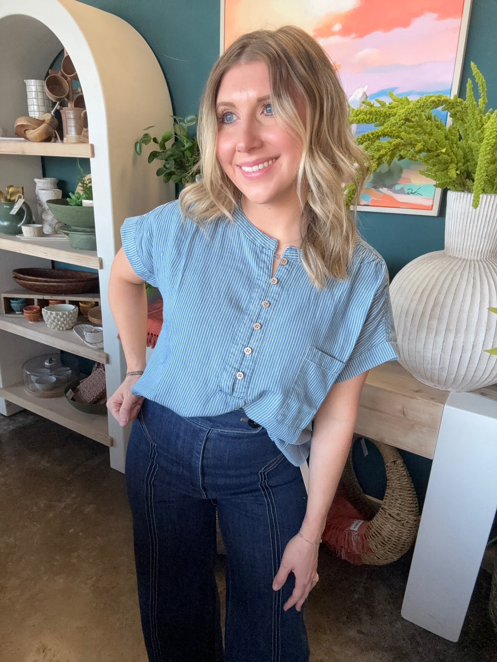 woman wearing blue and white pinstripe boutique blouse with button front