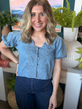 woman wearing embroidered chambray boutique top with puff sleeves and button front