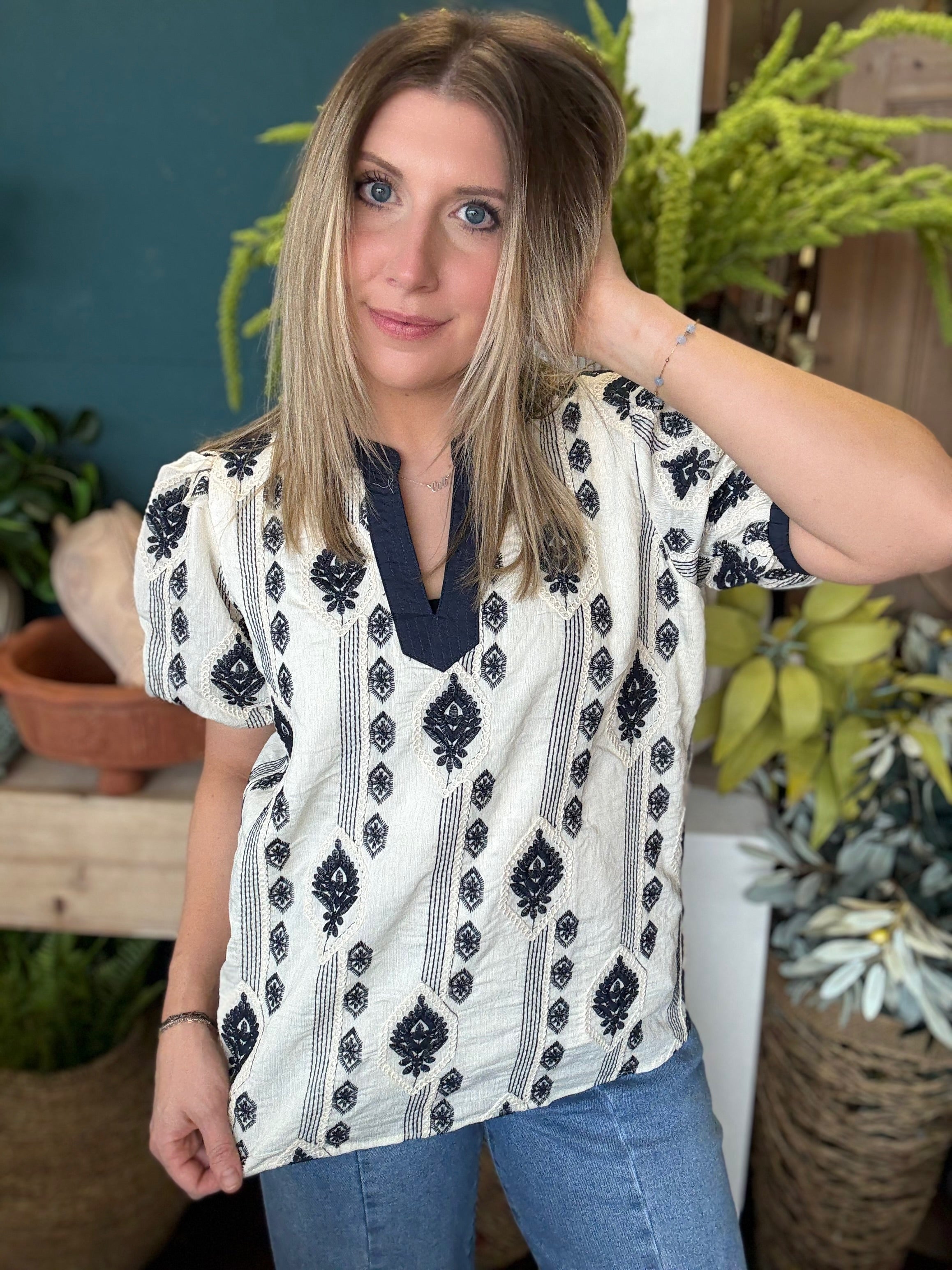 woman wearing boho embroidered split neck boutique blouse with black pattern