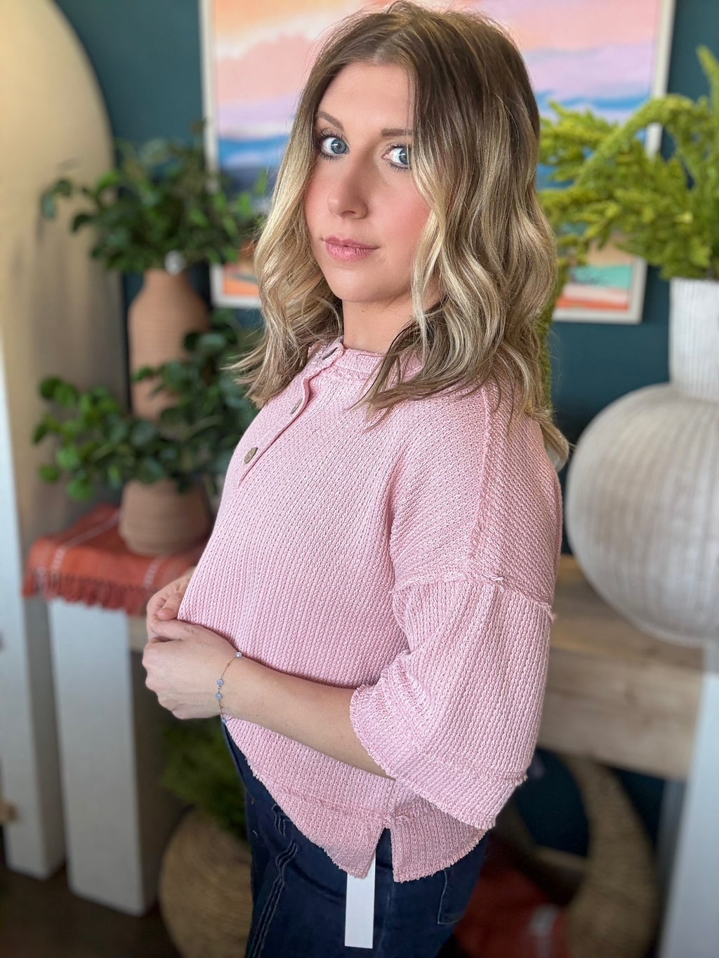 woman wearing blush pink waffle knit boutique top with button neckline