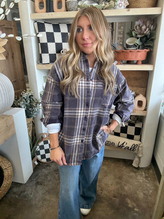 Woman wearing an oversized charcoal, taupe, cream, and brown plaid button-down shirt