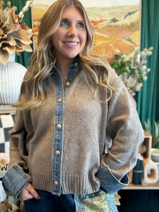 Woman wearing a latte knit sweater with a washed-denim collar, button placket, statement cuffs, and gold-tone buttons.