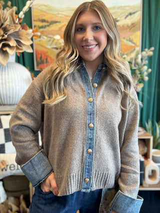 Woman wearing a latte knit sweater with a washed-denim collar, button placket, statement cuffs, and gold-tone buttons.