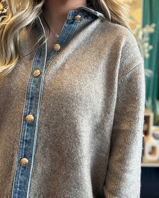 Woman wearing a latte knit sweater with a washed-denim collar, button placket, statement cuffs, and gold-tone buttons.