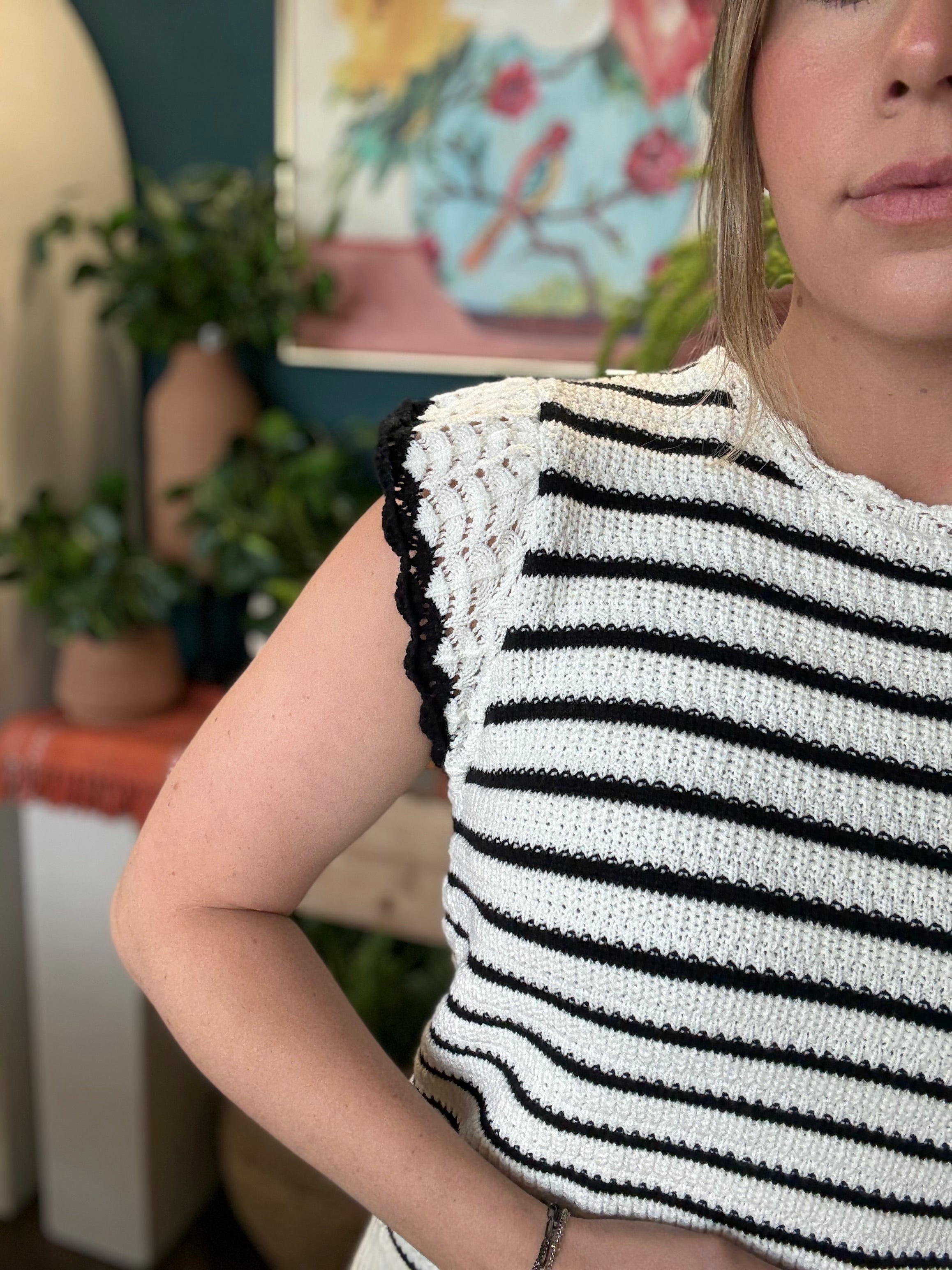 woman wearing black and ivory striped sweater top with crochet ruffle sleeves