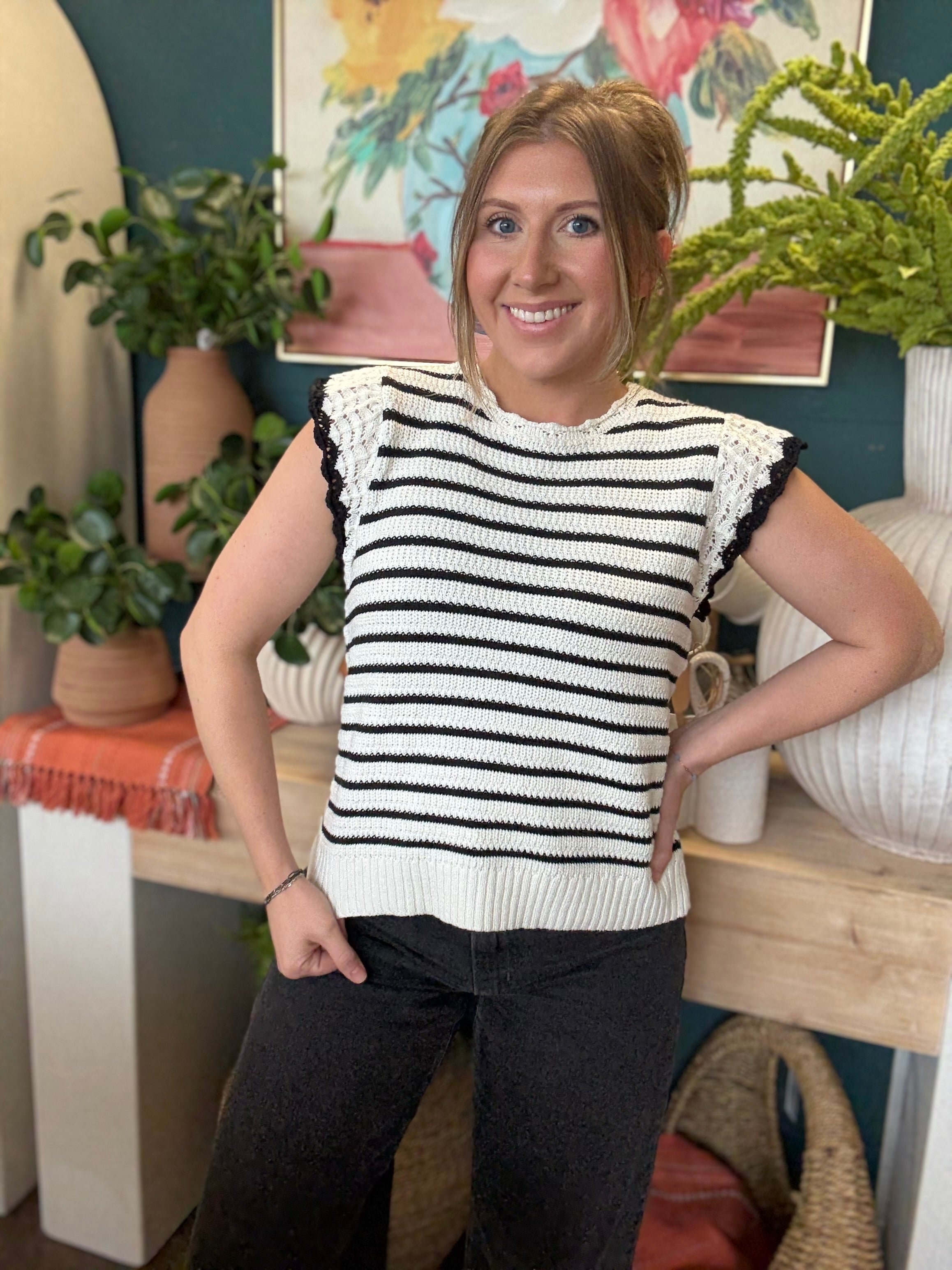 woman wearing black and ivory striped sweater top with crochet ruffle sleeves