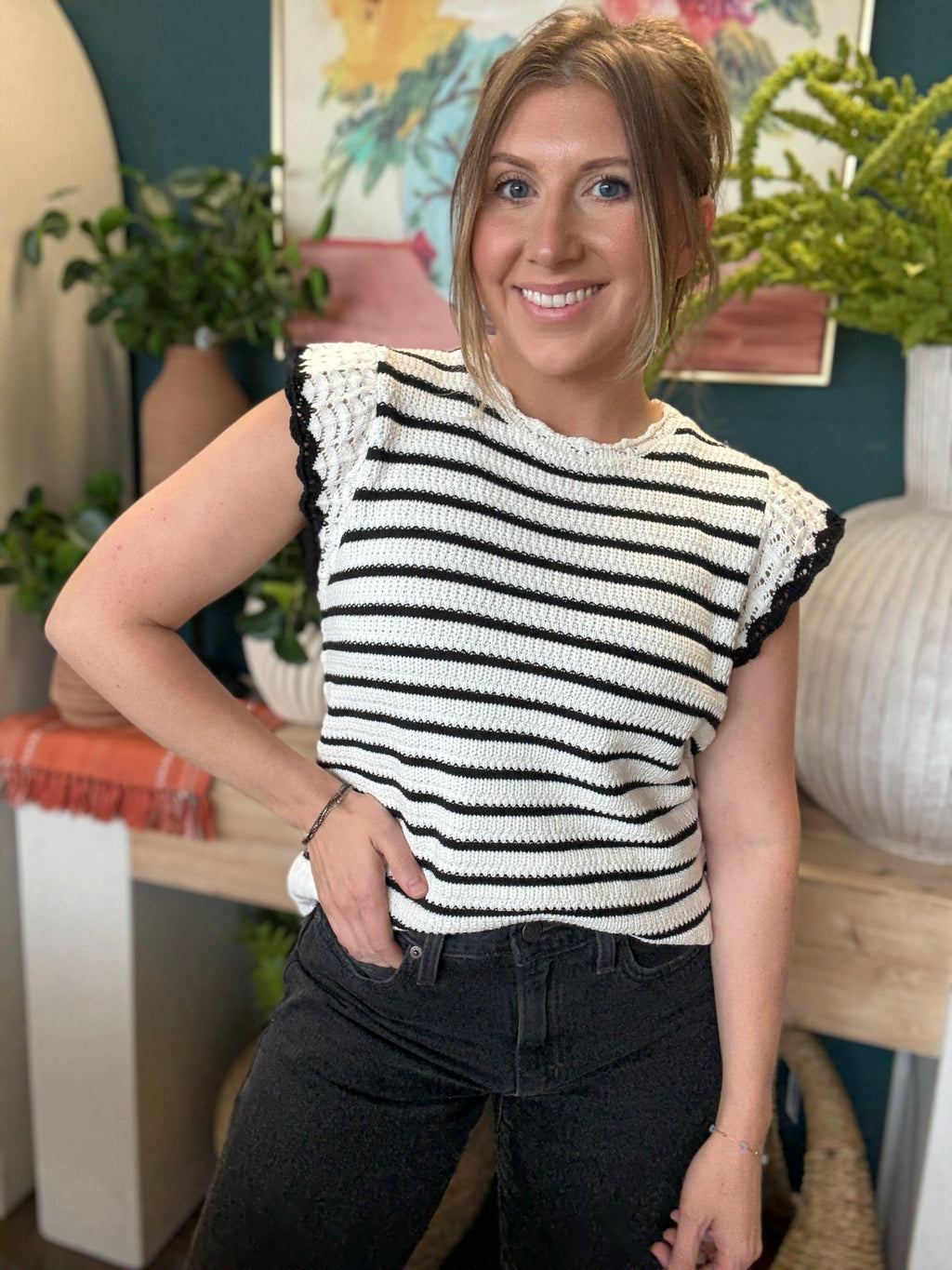 woman wearing black and ivory striped sweater top with crochet ruffle sleeves