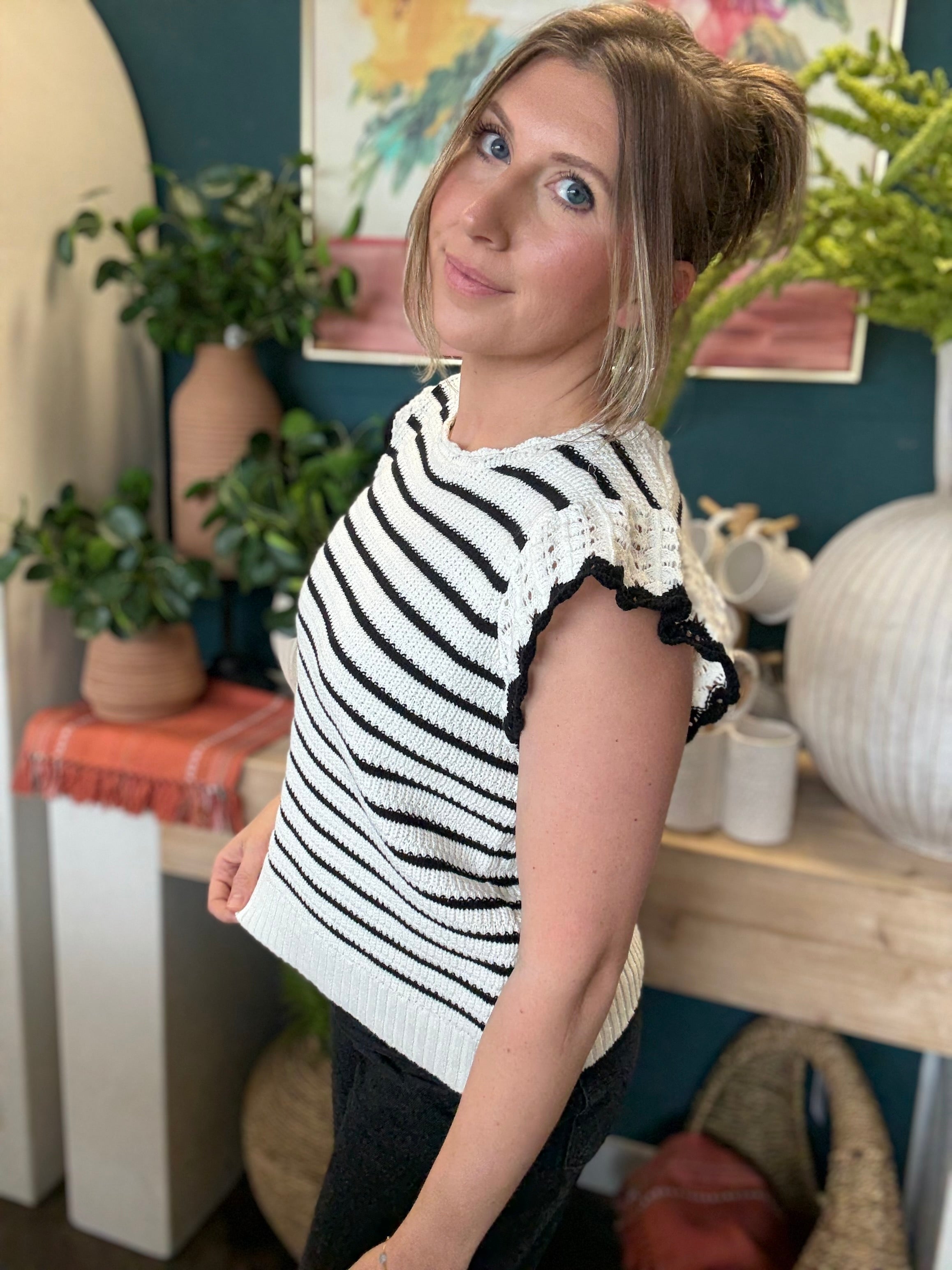 woman wearing black and ivory striped sweater top with crochet ruffle sleeves