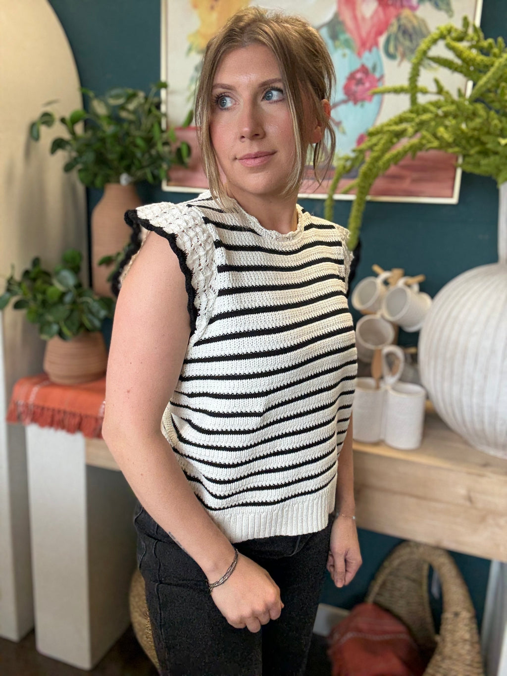woman wearing black and ivory striped sweater top with crochet ruffle sleeves