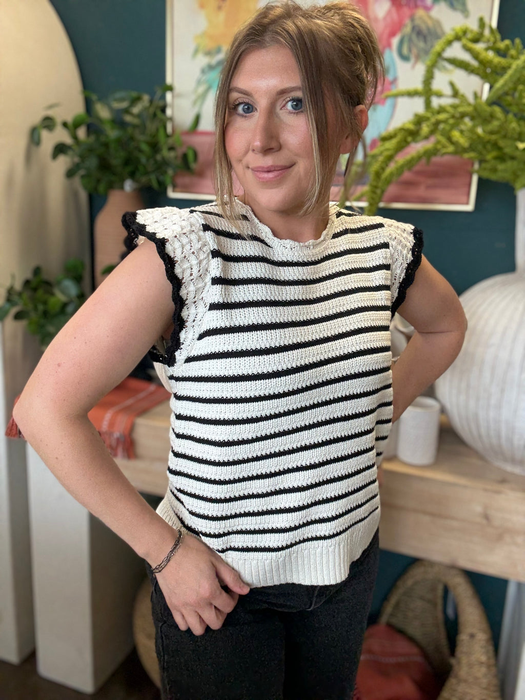 woman wearing black and ivory striped sweater top with crochet ruffle sleeves