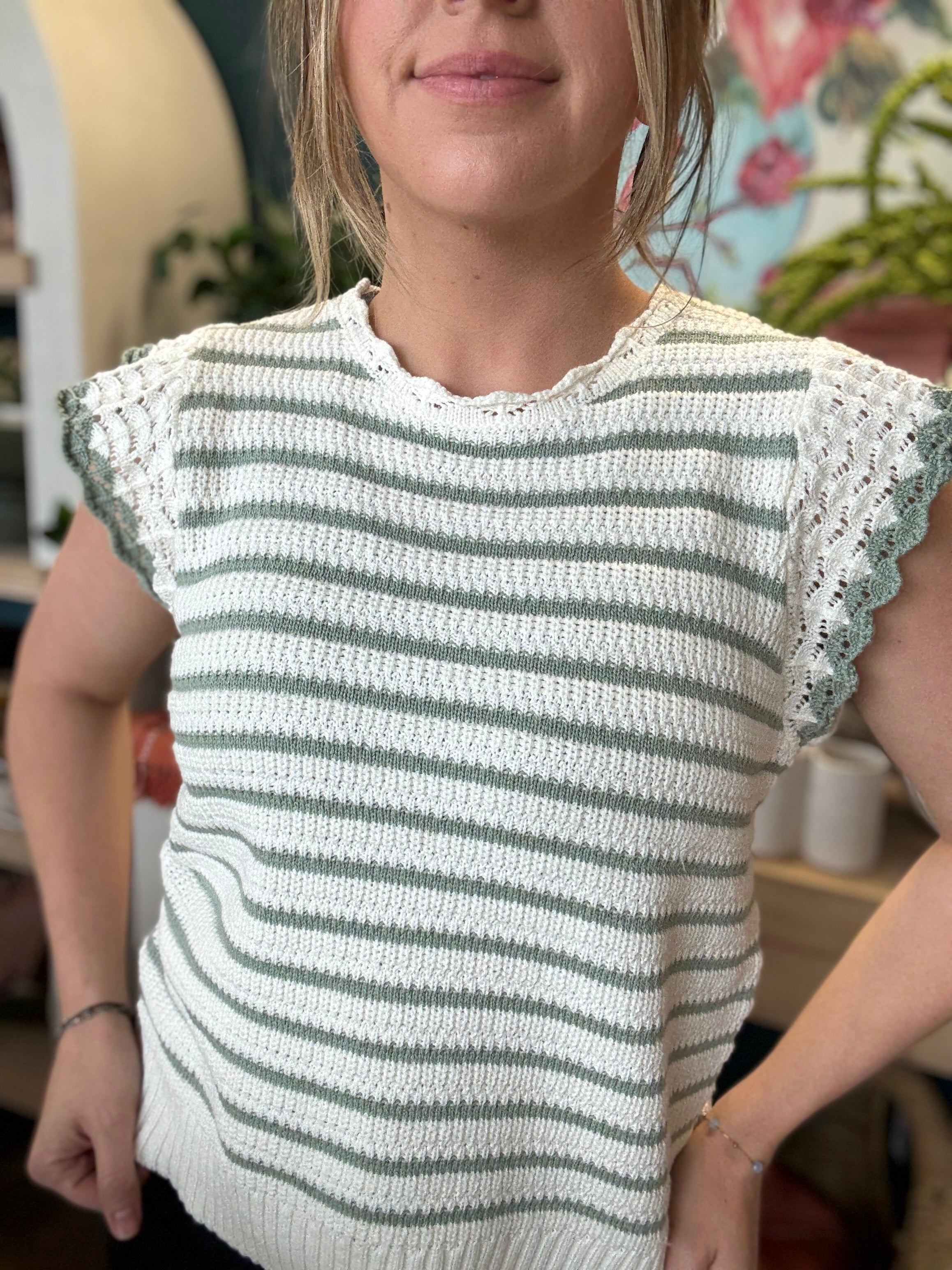woman wearing sage and ivory striped sweater top with crochet ruffle sleeves