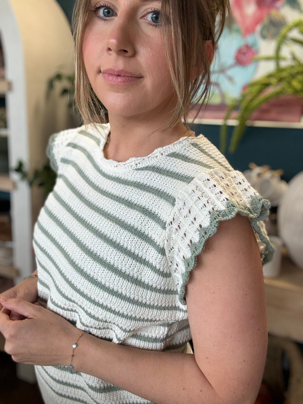 woman wearing sage and ivory striped sweater top with crochet ruffle sleeves