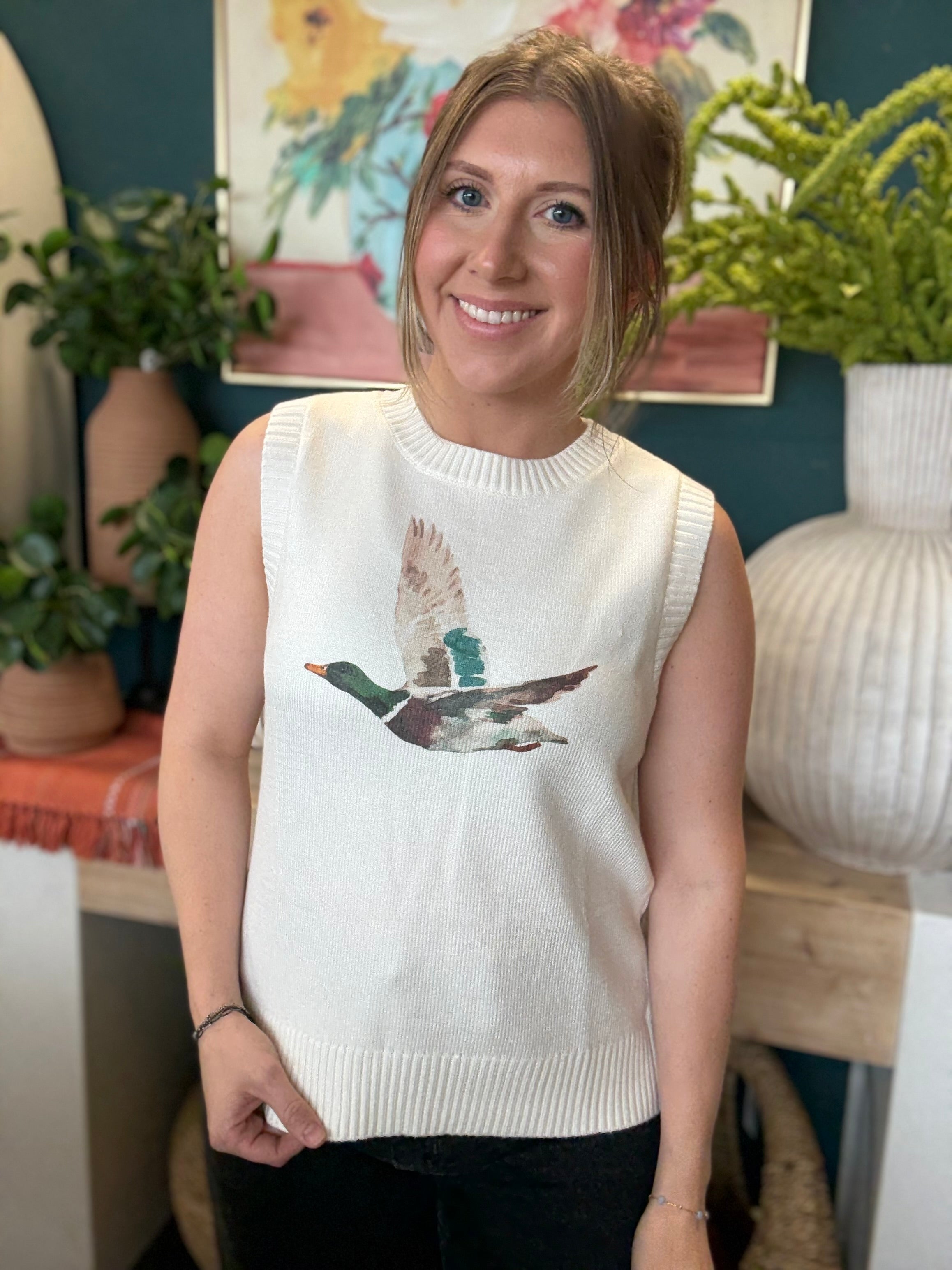 woman wearing ivory sweater vest with flying mallard duck graphic