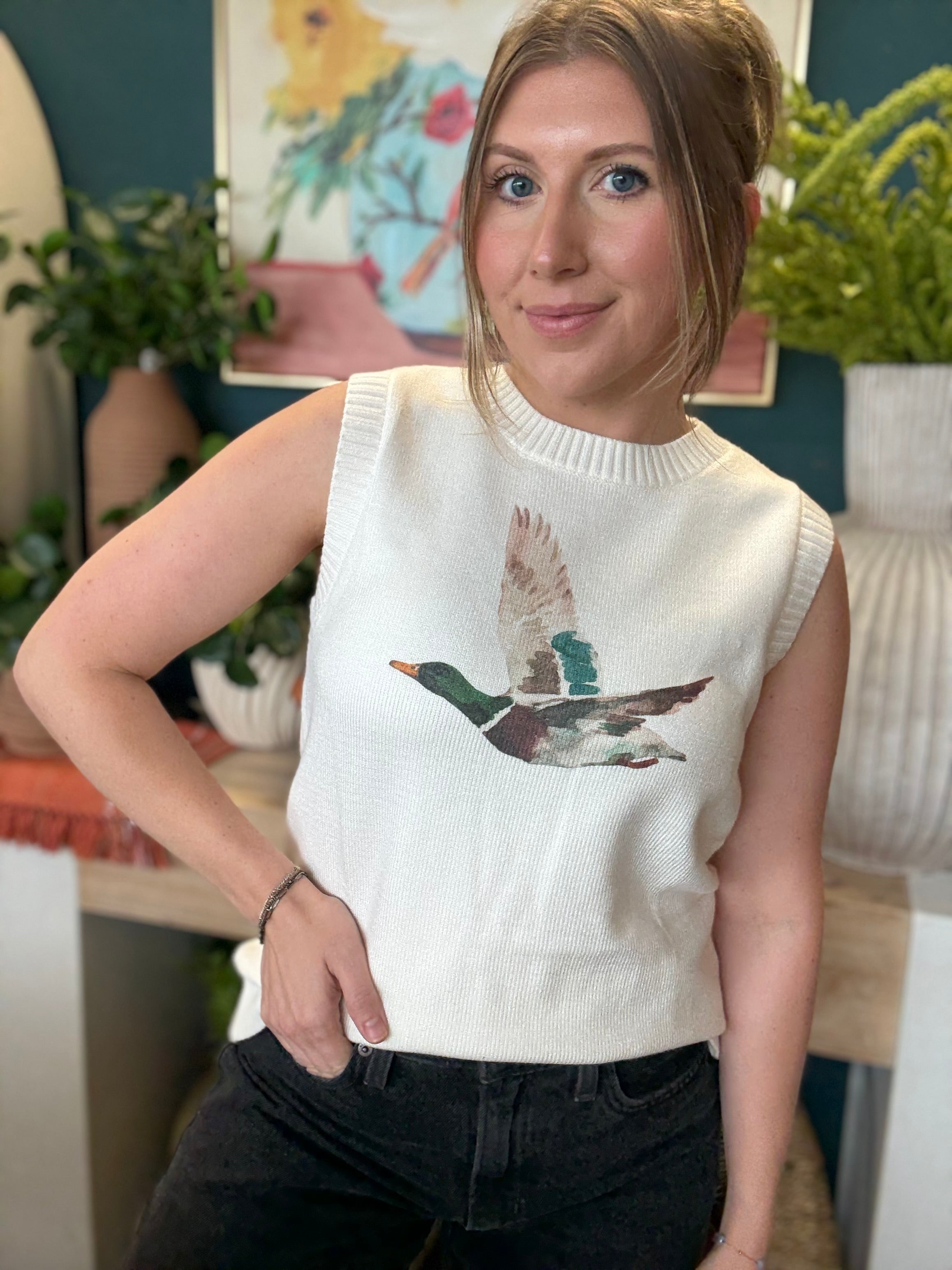 woman wearing ivory sweater vest with flying mallard duck graphic