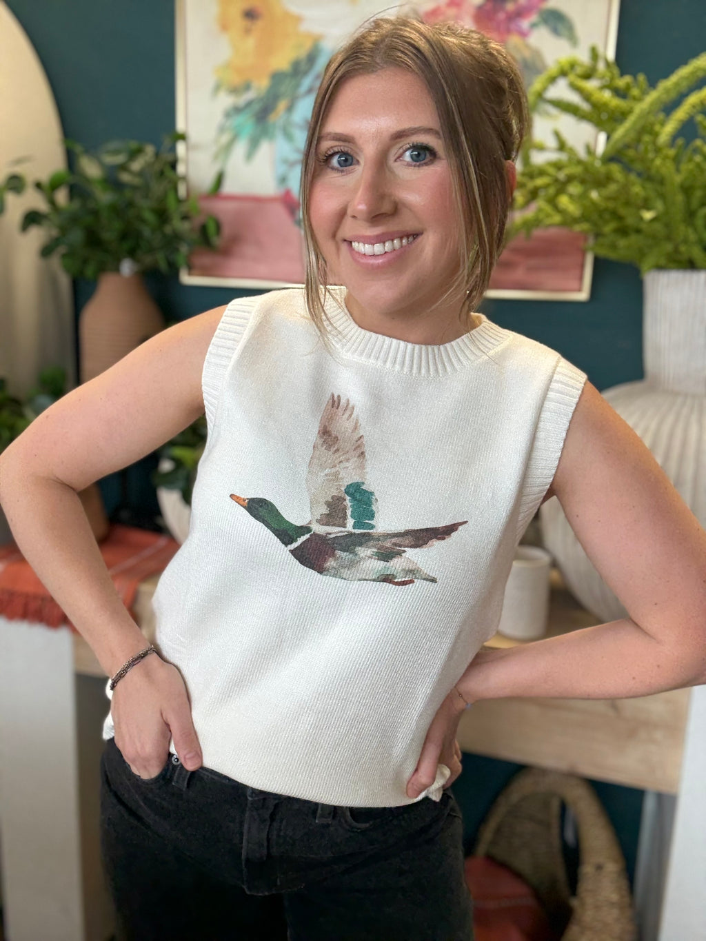 woman wearing ivory sweater vest with flying mallard duck graphic