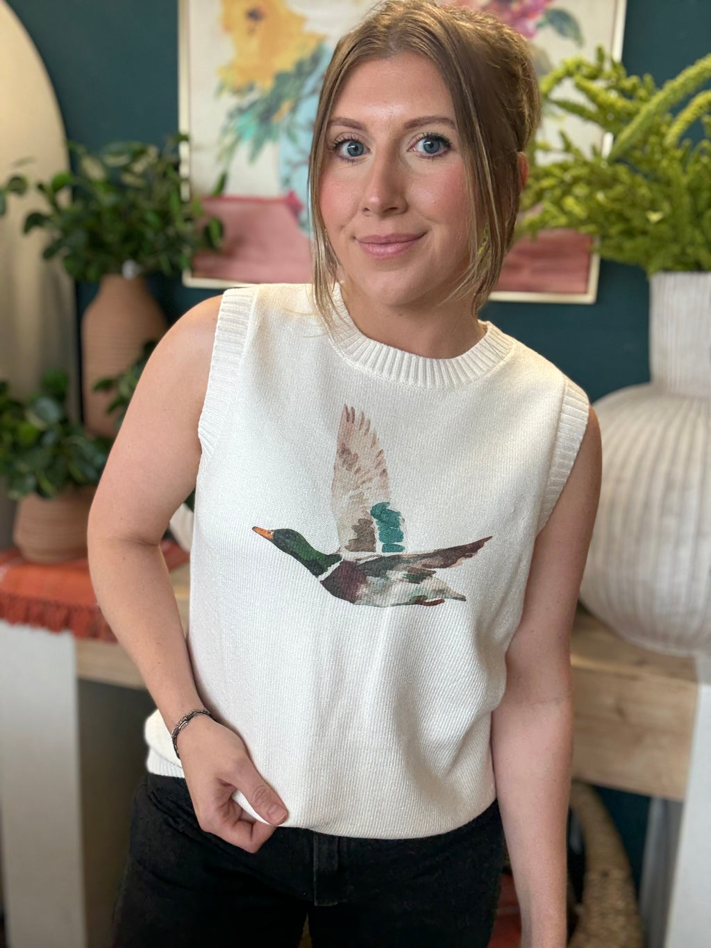 woman wearing ivory sweater vest with flying mallard duck graphic