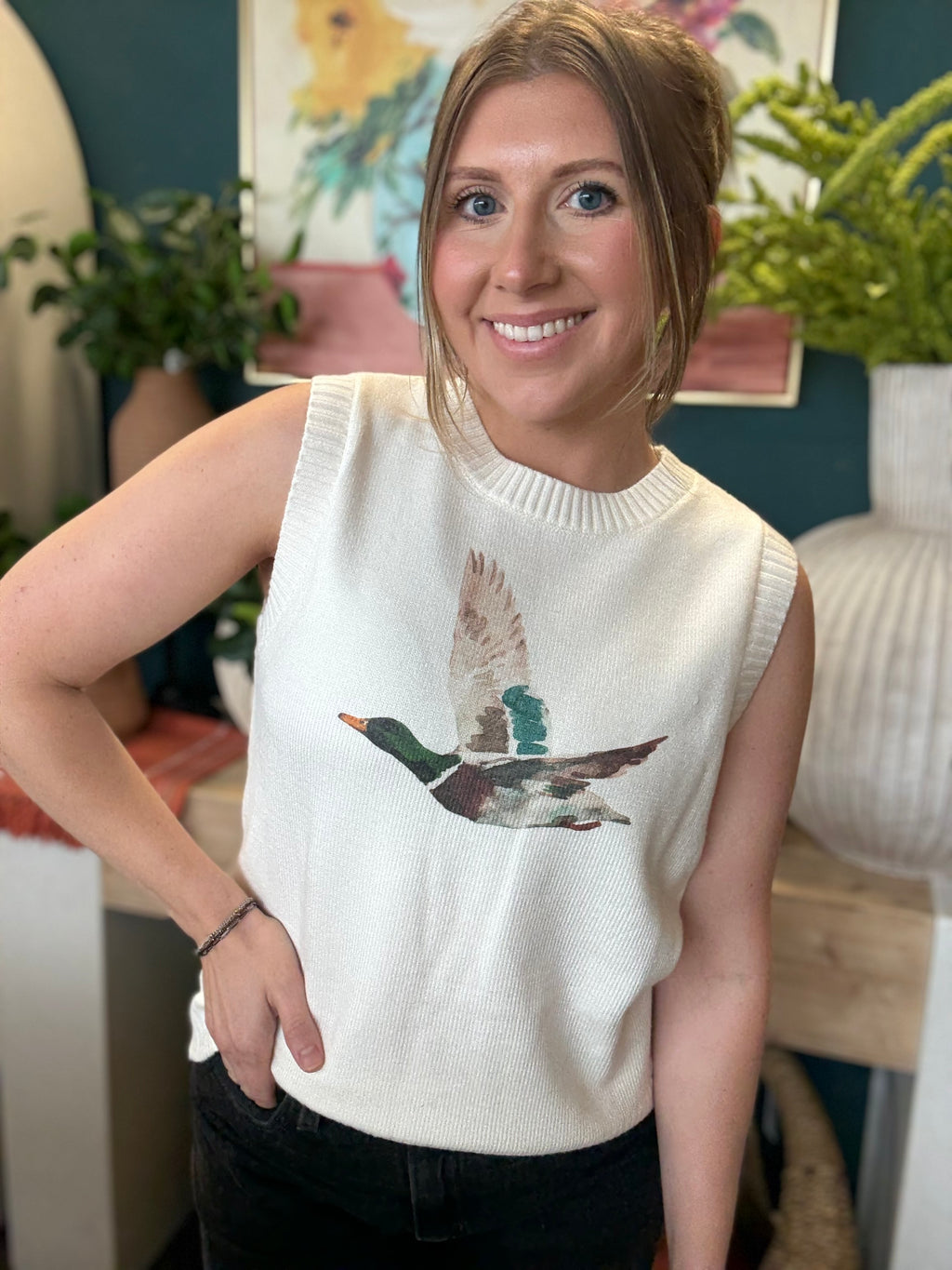 woman wearing ivory sweater vest with flying mallard duck graphic