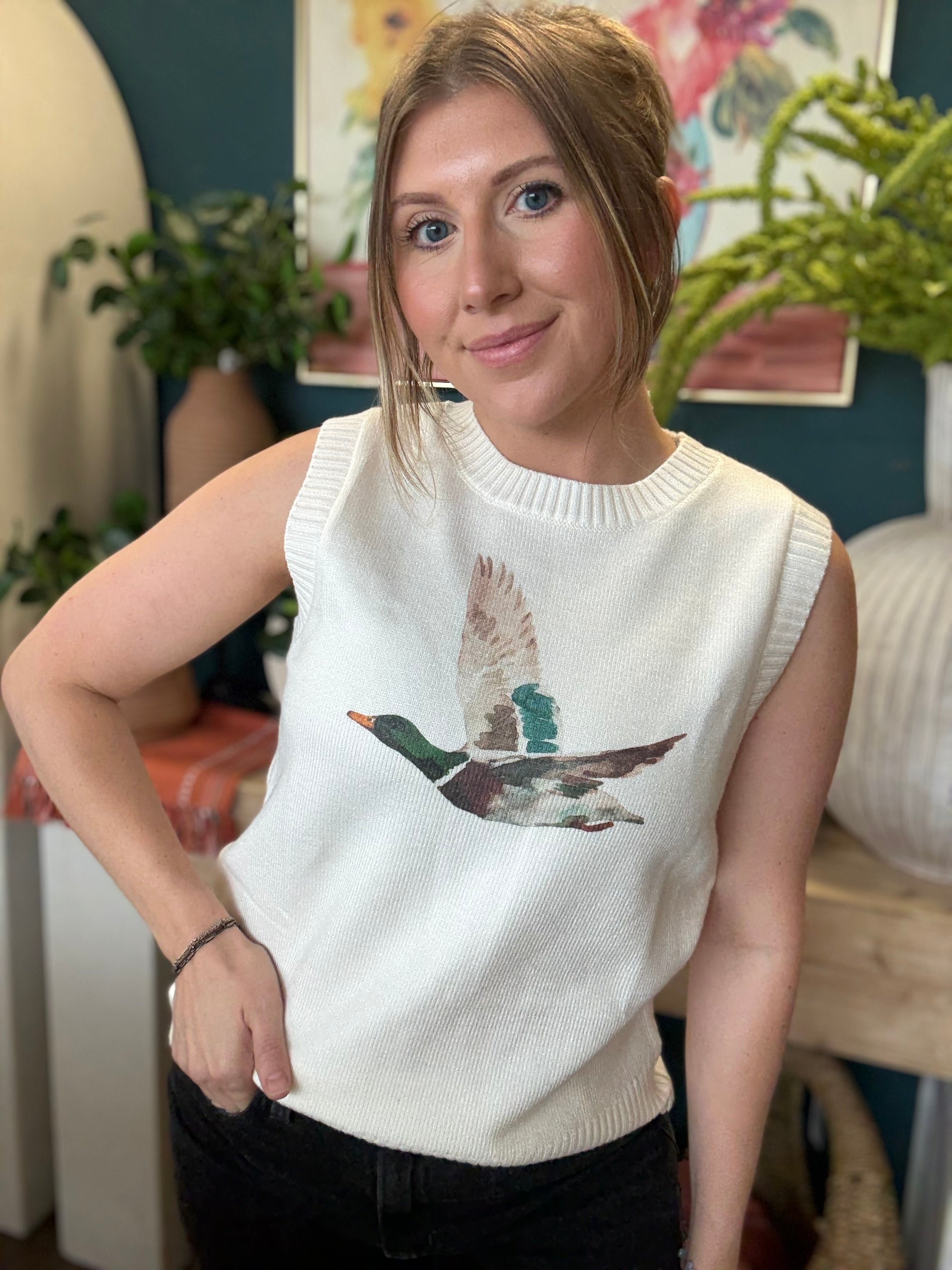 woman wearing ivory sweater vest with flying mallard duck graphic